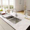 Franke 1.5 bowl stainless steel sink installed in a marble countertop kitchen island.