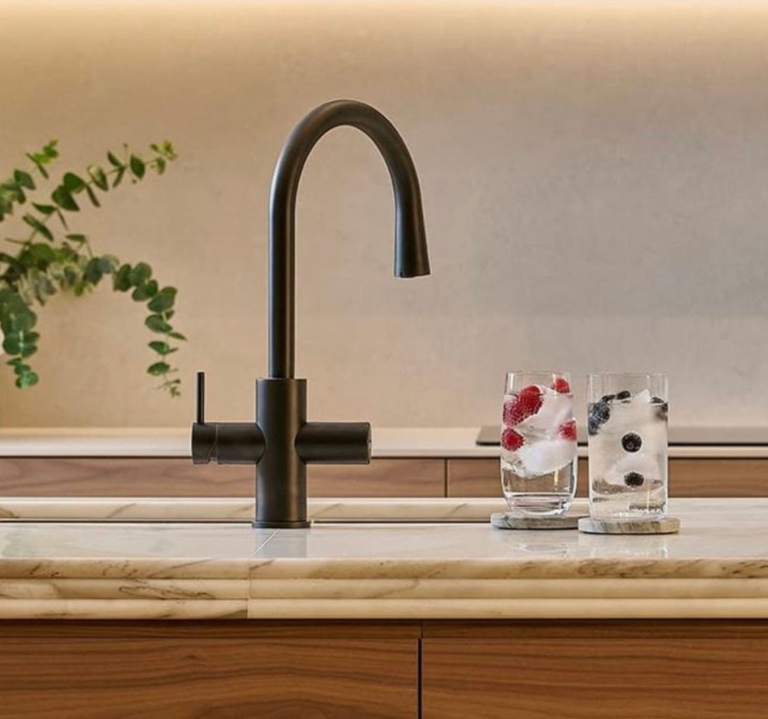 Black Zip Hydrotap Celsius Arc model with Chilled functionality in modern japandi kitchen with iced glasses of water on the countertop