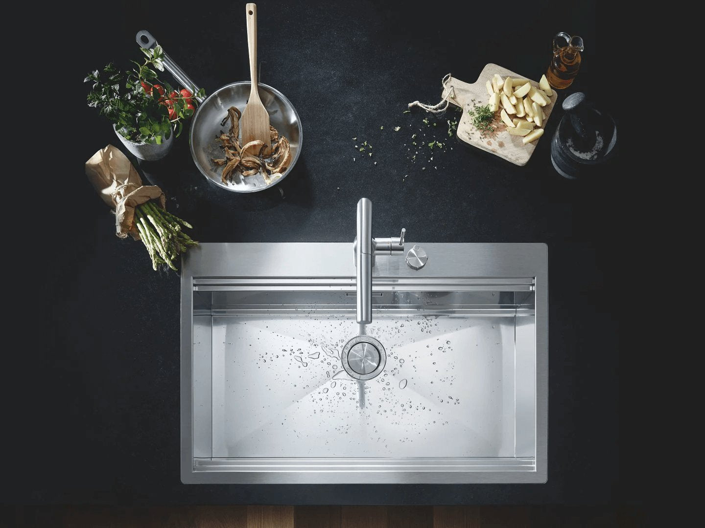 Stainless steel kitchen sink with a matching tap surrounded by savory ingredients.