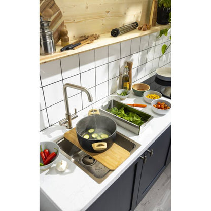 Abode Sytem Sync Accessory Trio AX1142 displayed on Abode System Sync kitchen sink lifestyle image shows hot pan filling with water in a kitchen, the pan is placed on the chopping board which fits neatly into the System Sync kitchen sink, around this ingredients are laid out as if prepared for coking a meal