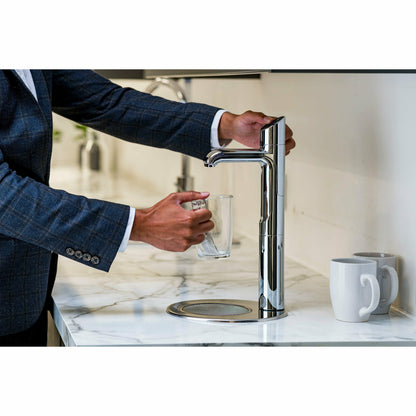Zip HydroTap Classic Plus G5 with Integrated Font (Bright Chrome) lifestyle image of business man dispensing hot water into glass teacup kitchen