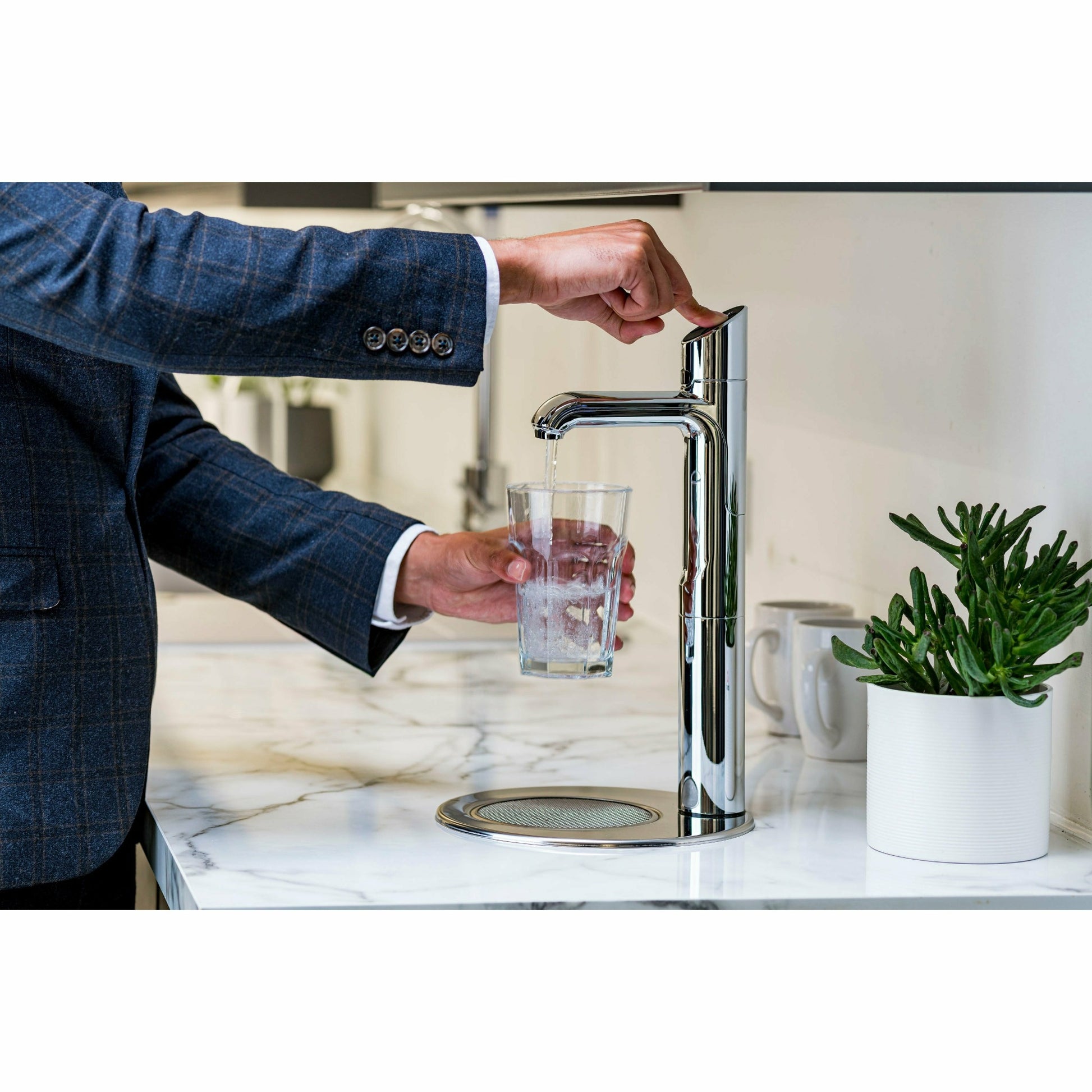 Zip HydroTap Classic Plus G5 with Integrated Font (Bright Chrome) lifestyle image of business man dispensing sparkling water in kitchen