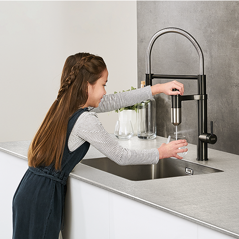 Franke Vital Capsule Filter 3-in-1 Semi-Pro Pull Out Kitchen Tap - Chrome Gun Metal finish lifestyle image in modern kitchen with child operating